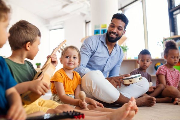 nursery-school-children-with-man-teacher-sitting-o-2022-01-19-00-04-00-utc.jpg